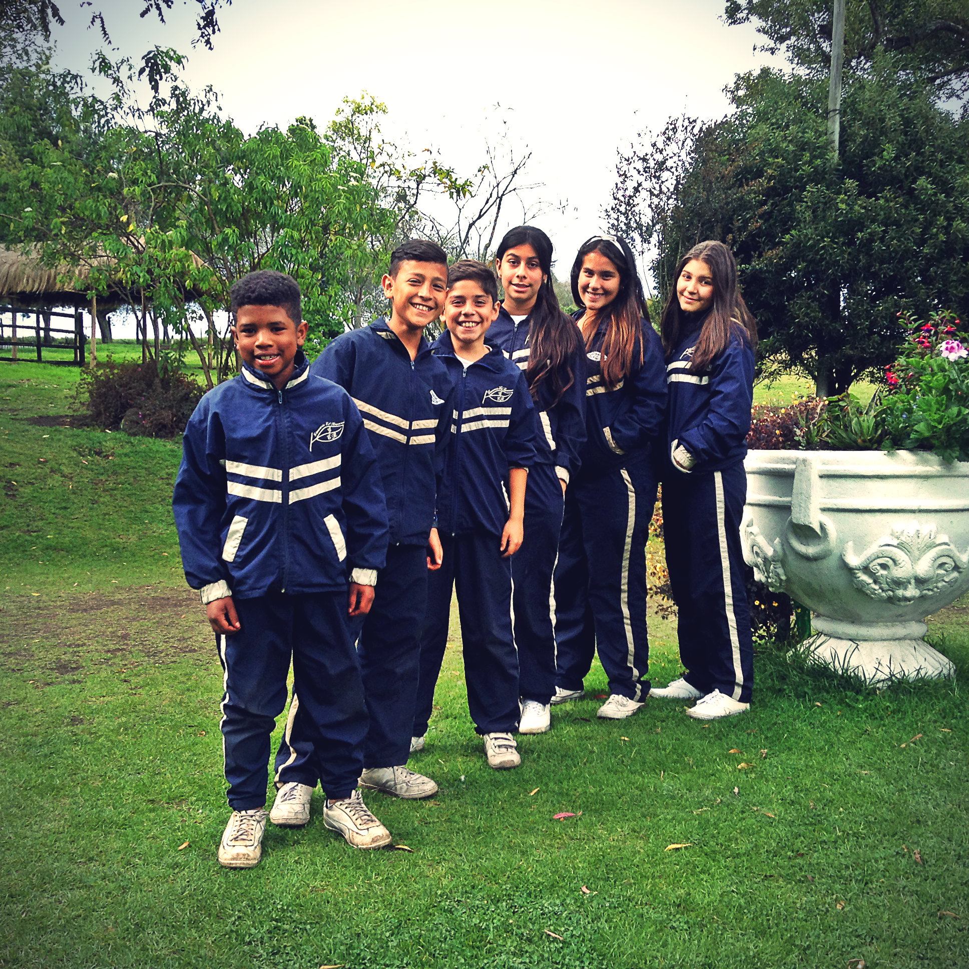 Estudiantes con uniforme deportivo en el jardín